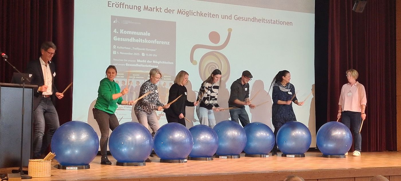 Geschicklichkeitsübung auf der Bühne mit Trommelstöcken und Bällen.