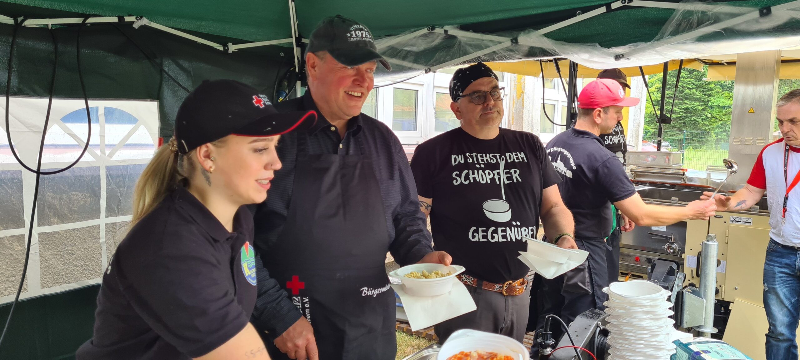 Bürgermeister Marco Jahns schenkt Nudeln mit Tomatensoße aus.