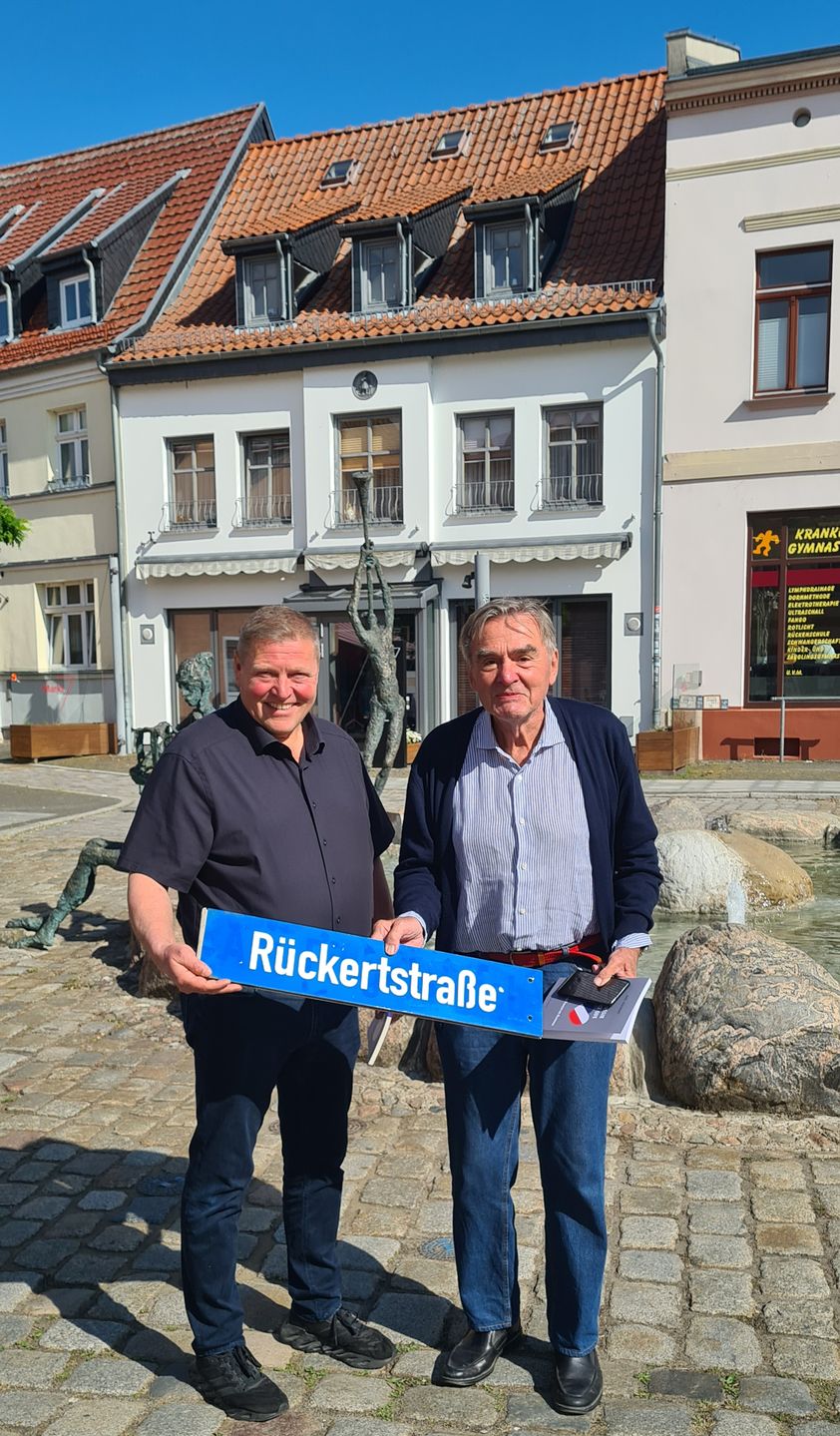 Marco Jahns und Axel Rückert stehen vor dem Rückert-Brunnen.