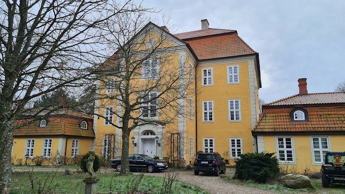 Es wird das Jadschloss in Quitzin gezeigt mit gelber Fassade und rotem Dach.