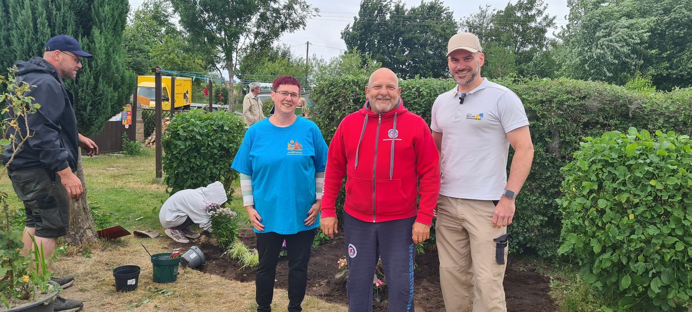 Naturbadchef Mario Gohs, Fördervereinsvorsitzende Carmen Wiedemann und Sebastian Kalden von der Stiftung Klima- und Umweltschutz MV, stehen vor einer Hecke im Schwimmbad.