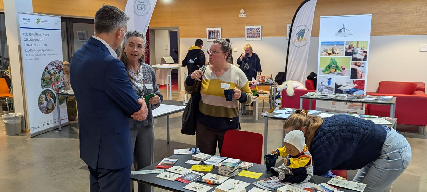 Der Landrat informiert sich, gemeinsam mit Besuchern, an einem Stand der Bürgerhilfe.