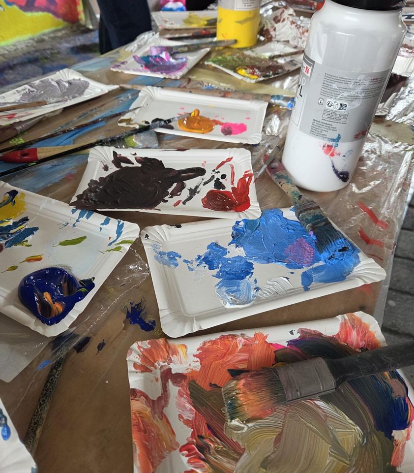 Der Maltisch mit Pinseln und vielen bunten Farben.