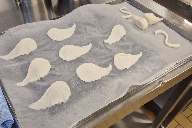 Auf Backpapier liegen ausgeschnittene Teigteile, die die Torte verzieren sollen.