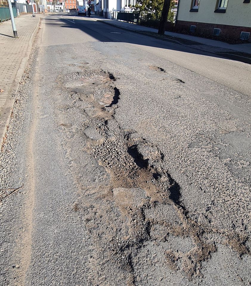 Auf diesem Bild ist eine ganze Fahrbahnhälfte mit Schlaglöchern übersät