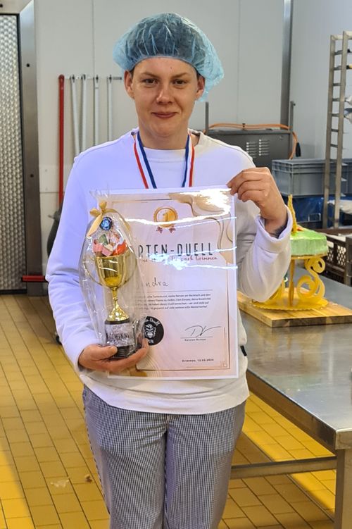 Die Siegerin mit Pokal und Urkunde.