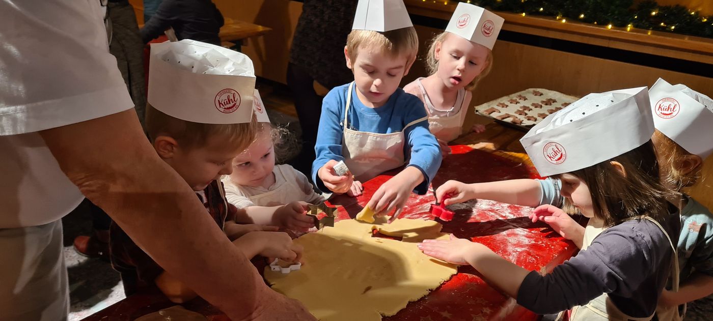 Kinder backen in der Weihnachtsbäckerei Plätzchen.