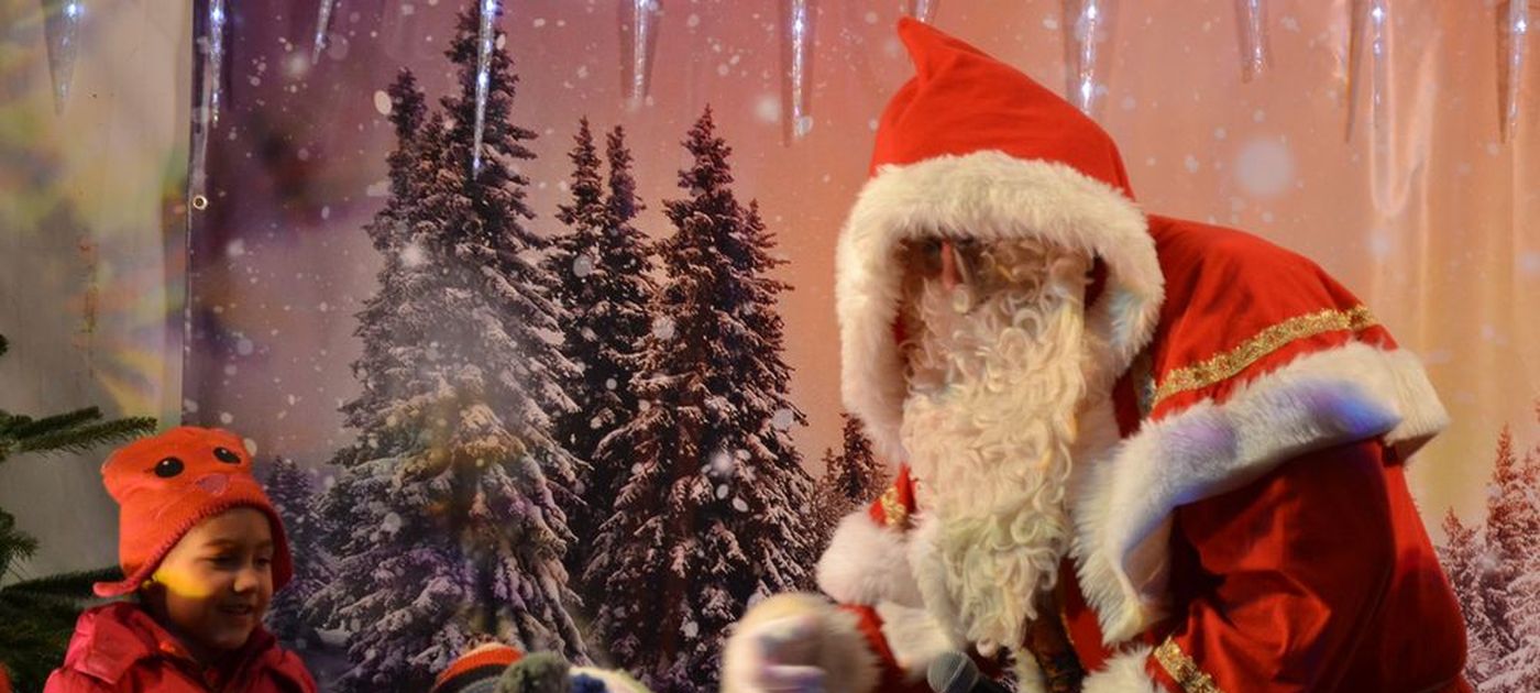 Der Weihnachtsmann beschenkt Kinder.